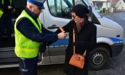 policjant zakłada kobiecie odblaskową opaskę