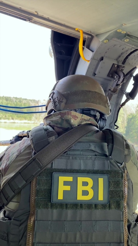 Policjant w umundurowaniu taktycznym z napisem FBI na plecach.
