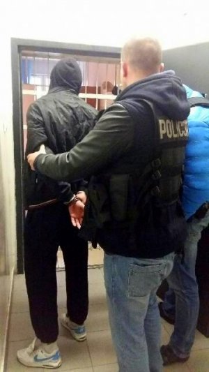 policjanci prowadzą zatrzymanego
