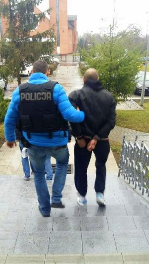policjanci prowadzą zatrzymanego