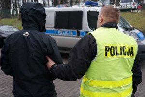 Policjant prowadzi zatrzymanego