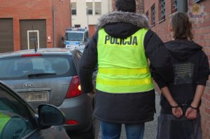 policjant prowadzi zatrzymanego