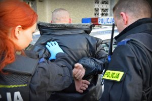 policjanci prowadzą zatrzymanego