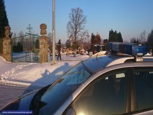 policyjny radiowóz przed cmentarzem