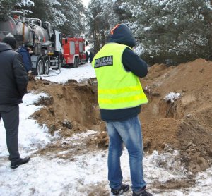 policjant na miejscu gdzie przebiega rurociąg paliwowy