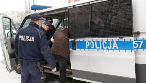 policjant prowadzi zatrzymanego