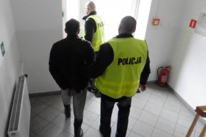 policjant prowadzi zatrzymanego