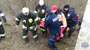 Funkcjonariusze transportują odnalezioną kobietę