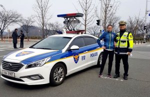 Sierż. Danuta Woszczek z koreańskim policjantem przy radiowozie