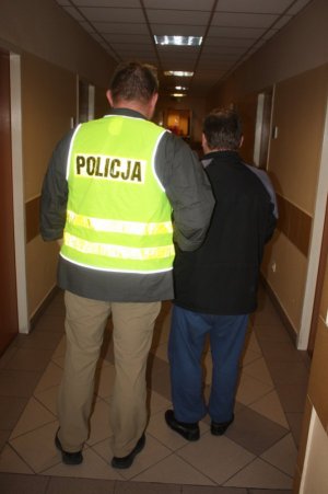 policjant prowadzi zatrzymanego