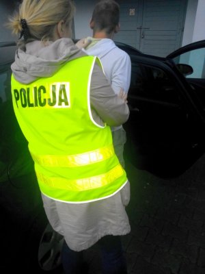 Policjantka prowadzi zatrzymanego