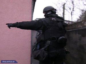 policjanci przy mieszkaniu, w którym doszło do zatrzymania