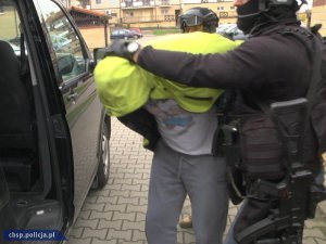 policjanci prowadzą zatrzymanego