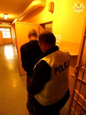 policjant prowadzi zatrzymanego