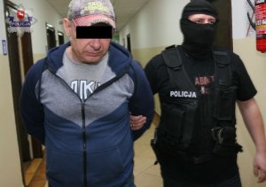 policjanci prowadzą zatrzymanego