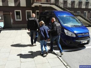 Policjanci wykonują czynności z zatrzymaną kobietą