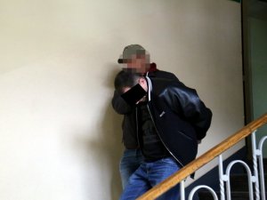policjanci prowadzą zatrzymanego