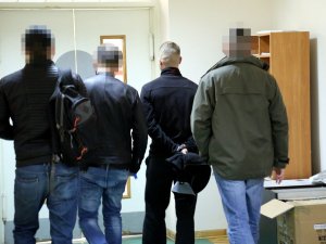 policjanci prowadzą zatrzymanych