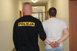 policjant prowadzi zatrzymanego