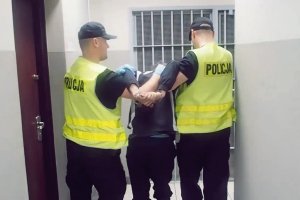 policjanci prowadzą zatrzymanego