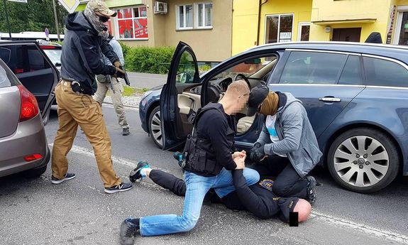 policjanci podczas akcji zatrzymania podejrzanego