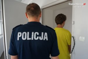 policjant prowadzi zatrzymanego