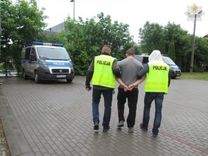 policjanci prowadzą zatrzymanego