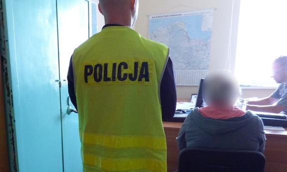 policjant przesłuchuje zatrzymaną kobietę