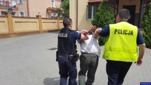 policjanci prowadzą zatrzymanego