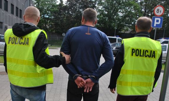 policjanci prowadzą zatrzymanego