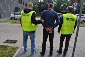 policjanci prowadzą zatrzymanego