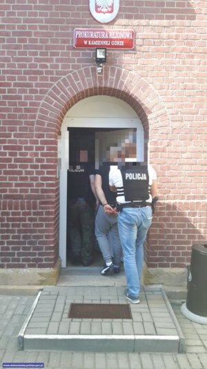 policjanci prowadzą zatrzymanego