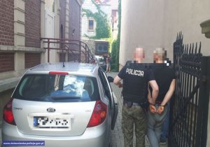policjanci prowadzą zatrzymanego