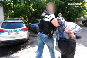 policjant prowadzi zatrzymanego