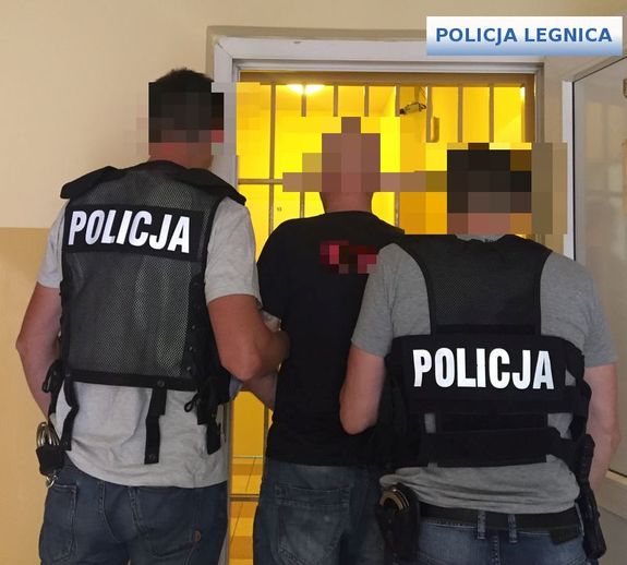Policjanci wykonujący czynności z zatrzymanym