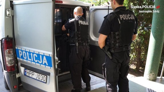 Policjanci wykonujący czynności z zatrzymanym