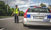 policjant ruchu drogowego na drodze i policyjny radiowóz