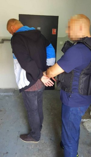 policjant prowadzi zatrzymanego