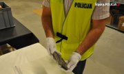 policjant trzyma siekierę neolityczną