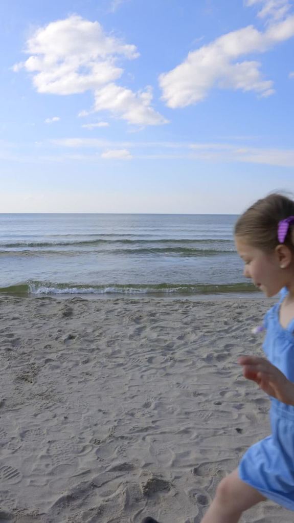 Dziewczynka biegnąca po plaży.