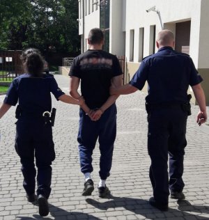 policjanci prowadzą zatrzymanego