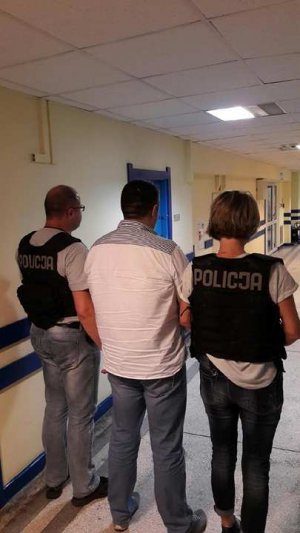 zatrzymany mężczyzna prowadzony przez policjantów