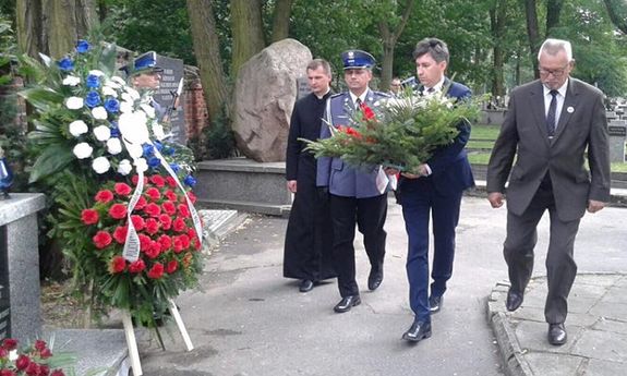 składanie kwiatów przed obeliskiem