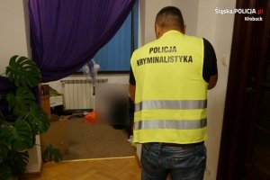 policjant przeprowadza czynności w mieszkaniu