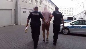 policjant prowadzi zatrzymanego