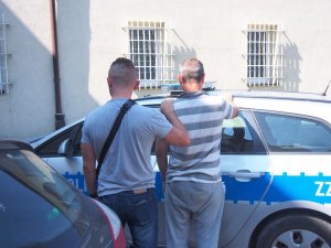 policjant prowadzi zatrzymanego