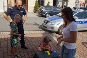 policjant obserwuje dziewczynkę próbującą wykonać zadanie w alkogoglach