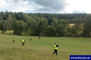 policjanci przeszukują teren - widok od tyłu