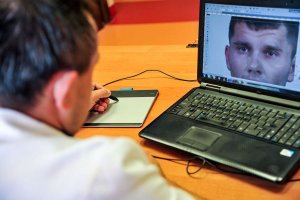 zbliżenie na mężczyznę oglądającego twarz na ekranie laptopa