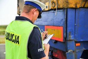 policjant zapisuje coś przed naczepą